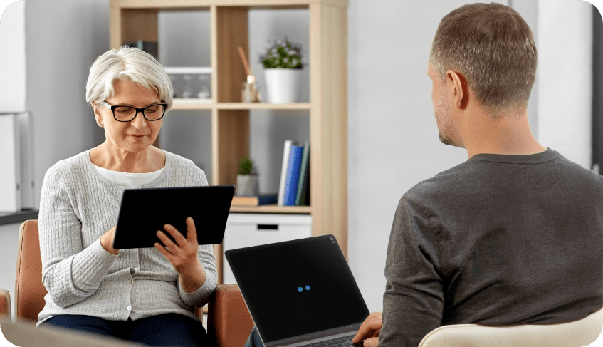 Picture of remotEMDR being user during an in-person therapy session. The therapist is holding her tablet and uses it to control the BLS being displayed on the screen of a laptop held by the client sitting in front of her.